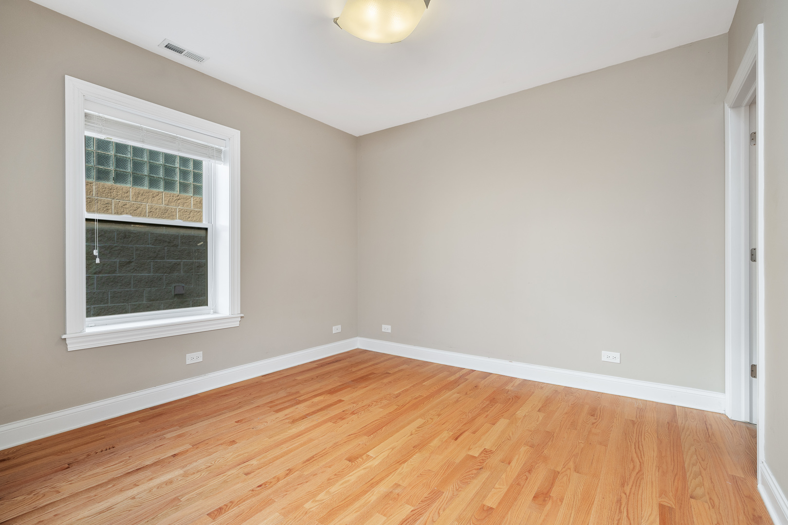 2142 West Addison Street, Unit 3B Chicago, IL 60618 - Photo 7 of 10 a view of an empty room with wooden floor and a window