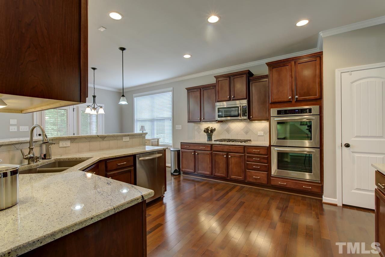 4001 Red Grape Drive Raleigh, NC 27607 - Photo 8 of 25 a kitchen with kitchen island a counter space a sink appliances and cabinets