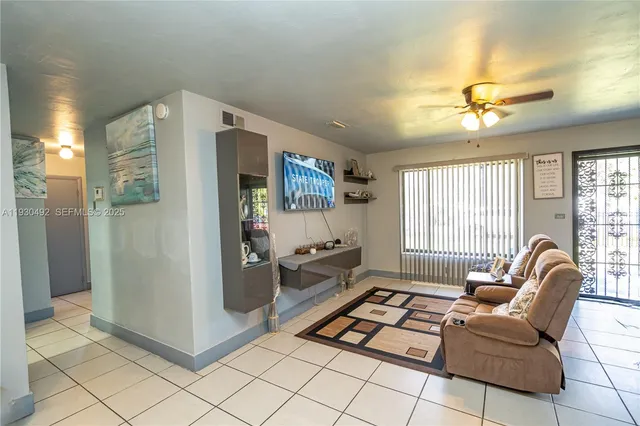 a living room with stainless steel appliances furniture and a window