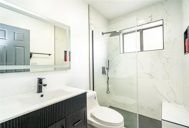 a bathroom with a sink a toilet and shower