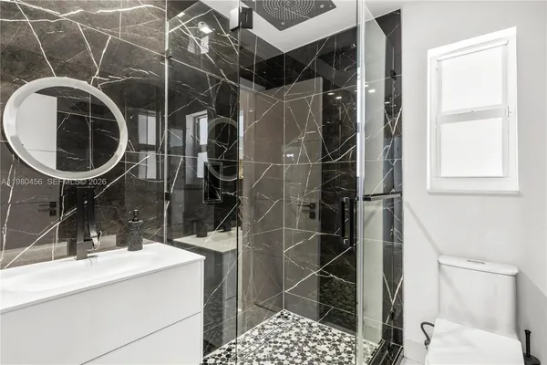 a bathroom with a sink toilet and shower