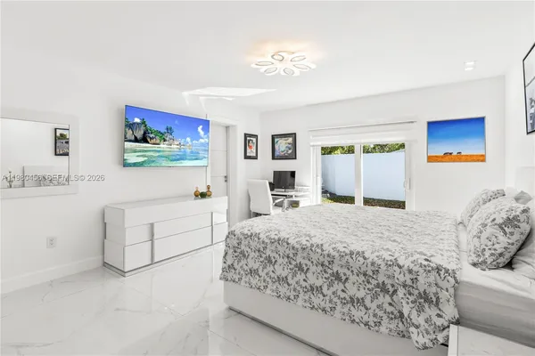 a bedroom with a large bed a chandelier and closet