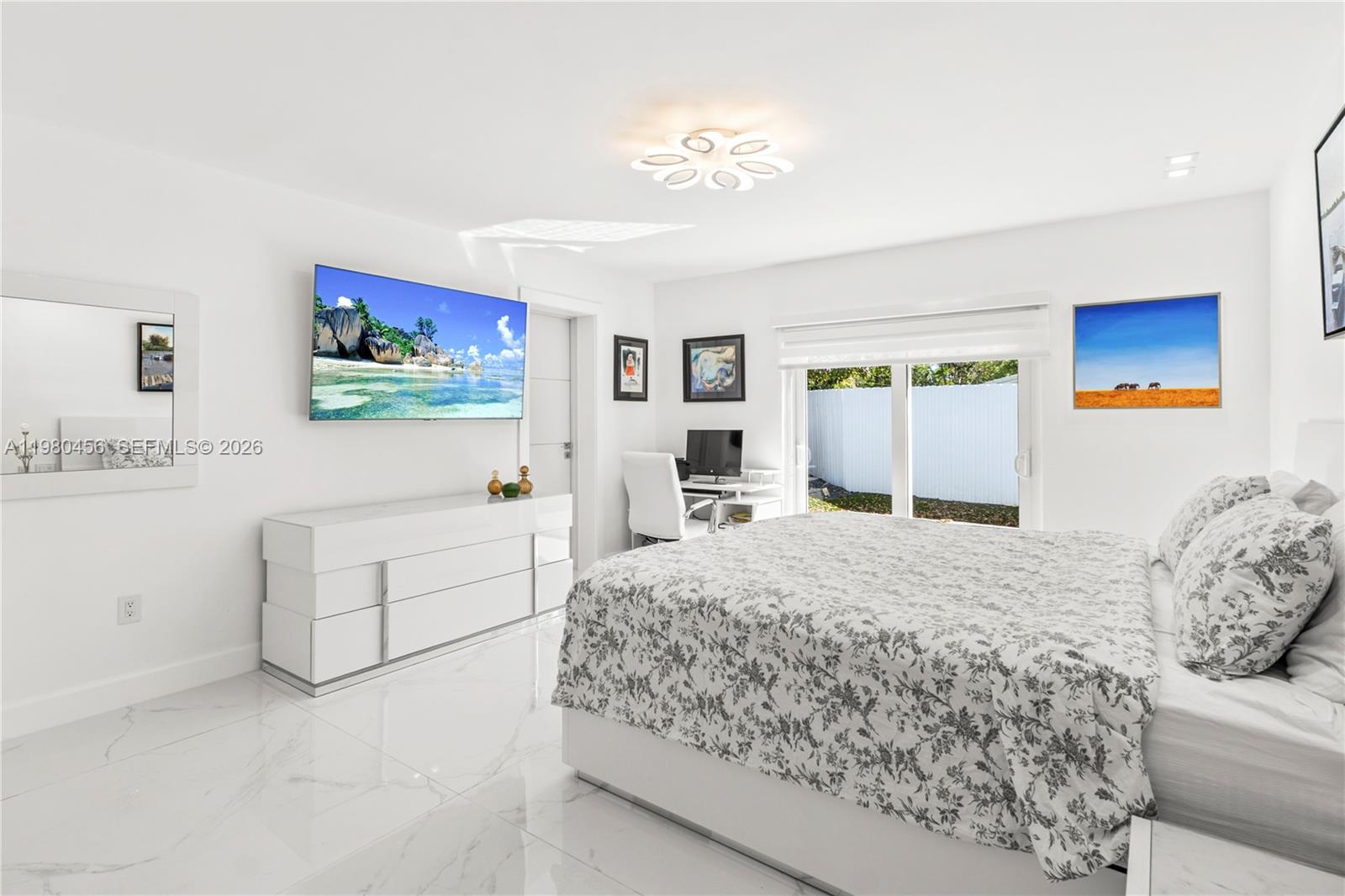 12401 Southwest 72nd Avenue Pinecrest, FL 33156 - Photo 14 of 35 a bedroom with a large bed and a flat screen tv