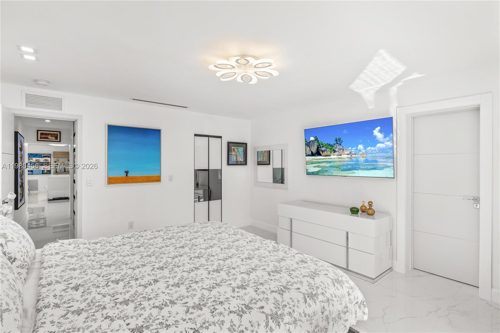 12401 Southwest 72nd Avenue Pinecrest, FL 33156 - Photo 15 of 35 a bedroom with a large bed a chandelier and closet