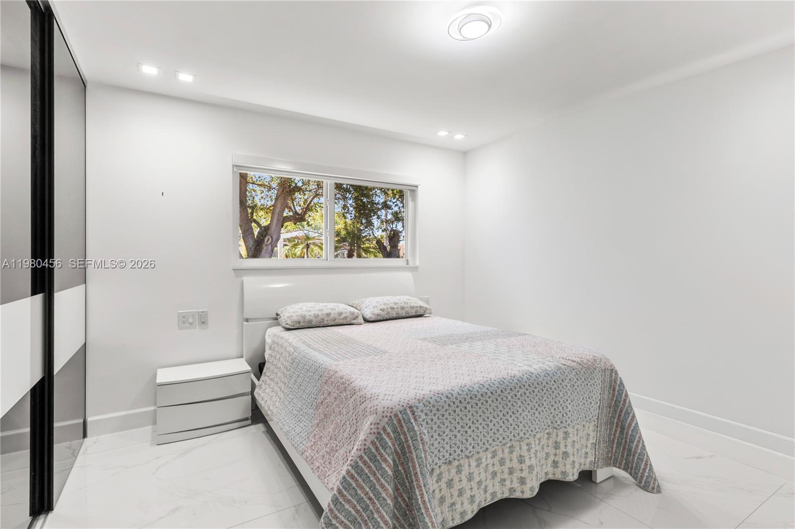 12401 Southwest 72nd Avenue Pinecrest, FL 33156 - Photo 20 of 35 a bedroom with a bed and a window