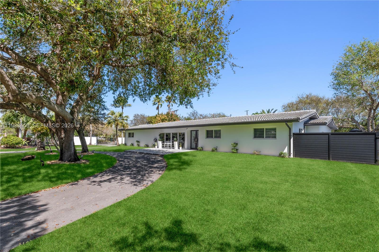 12401 Southwest 72nd Avenue Pinecrest, FL 33156 - Photo 29 of 35 a front view of a house with yard garden and trees