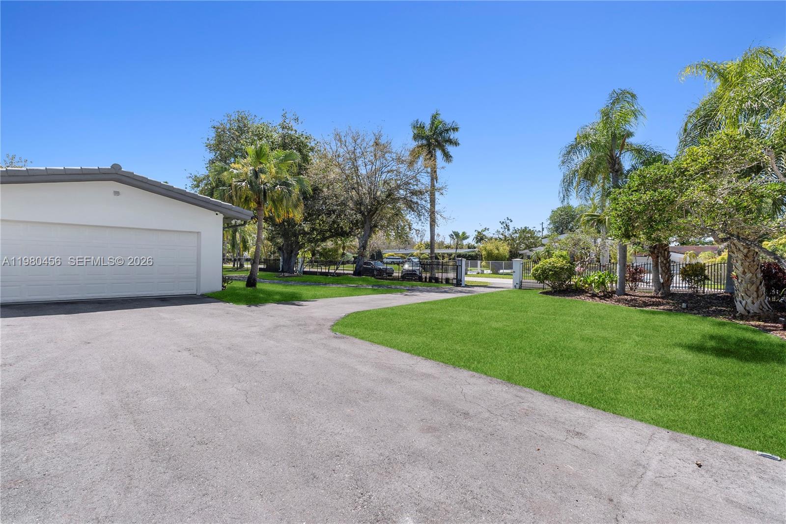 12401 Southwest 72nd Avenue Pinecrest, FL 33156 - Photo 32 of 35 a view of a house with a yard and garage