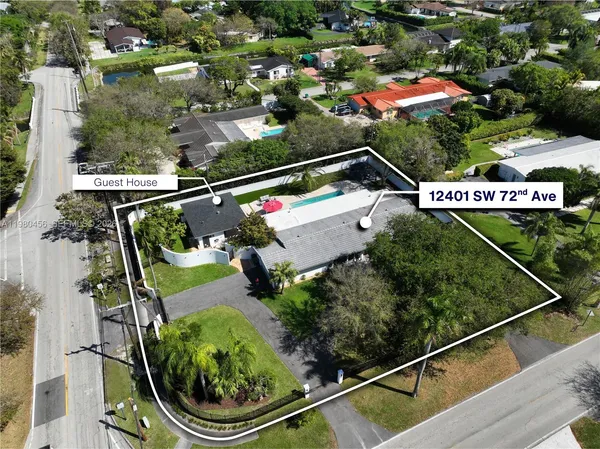 an aerial view of a house with a yard and a large tree