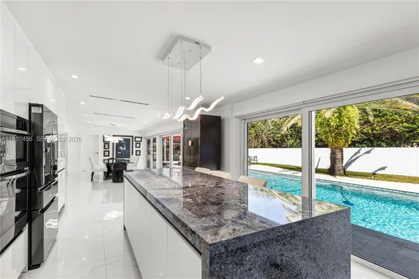 a kitchen with stainless steel appliances granite countertop a sink and a large window