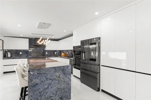 a kitchen with stainless steel appliances granite countertop a refrigerator and a stove