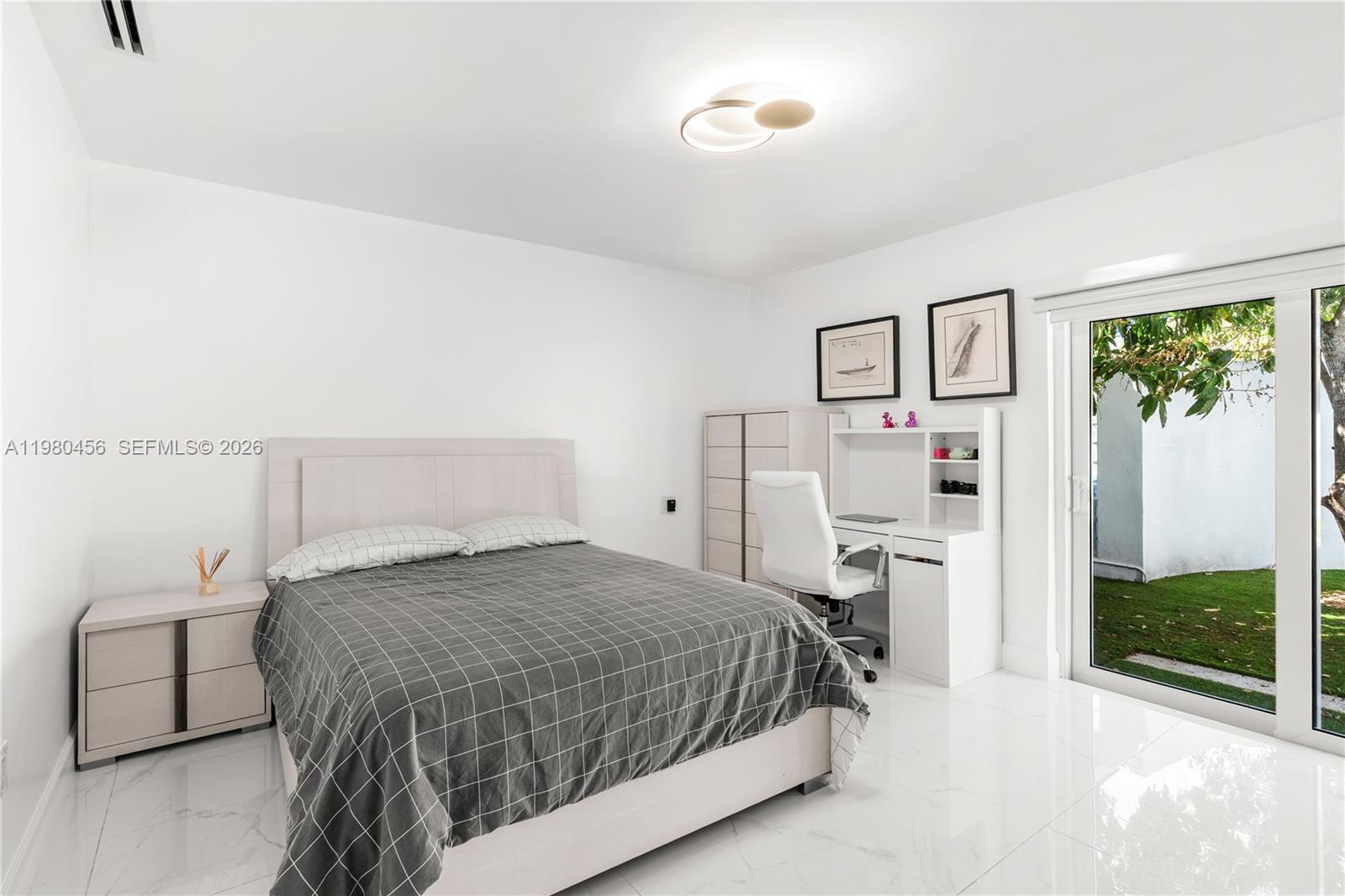 12401 Southwest 72nd Avenue Pinecrest, FL 33156 - Photo 10 of 35 a bedroom with a bed and a flat tv screen on dresser