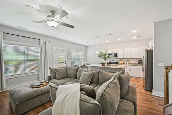 a living room with stainless steel appliances kitchen island granite countertop furniture and a large window