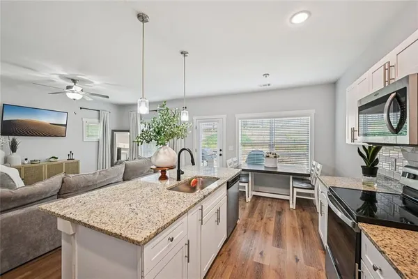 a kitchen with stainless steel appliances granite countertop a refrigerator and a sink