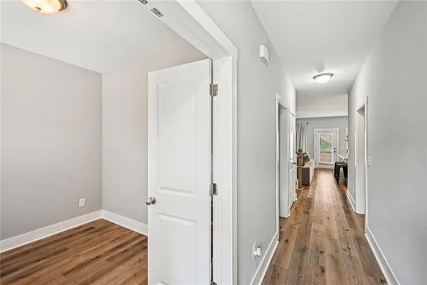 a view of a hallway with wooden floor and entryway