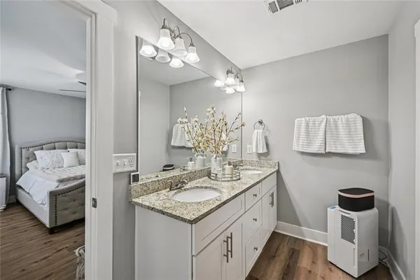 a bathroom with a granite countertop sink a large mirror and a shower