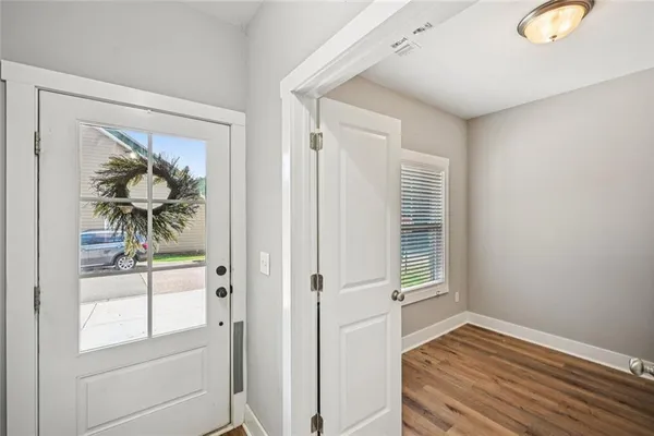 a kitchen with stainless steel appliances granite countertop a stove top oven a sink dishwasher a dining table and chairs with wooden floor
