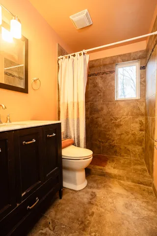 a bathroom with a sink a toilet and shower