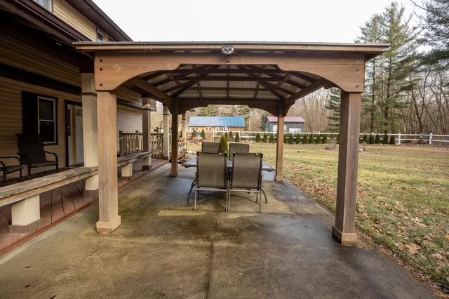 a backyard of a house with barbeque oven table and chairs