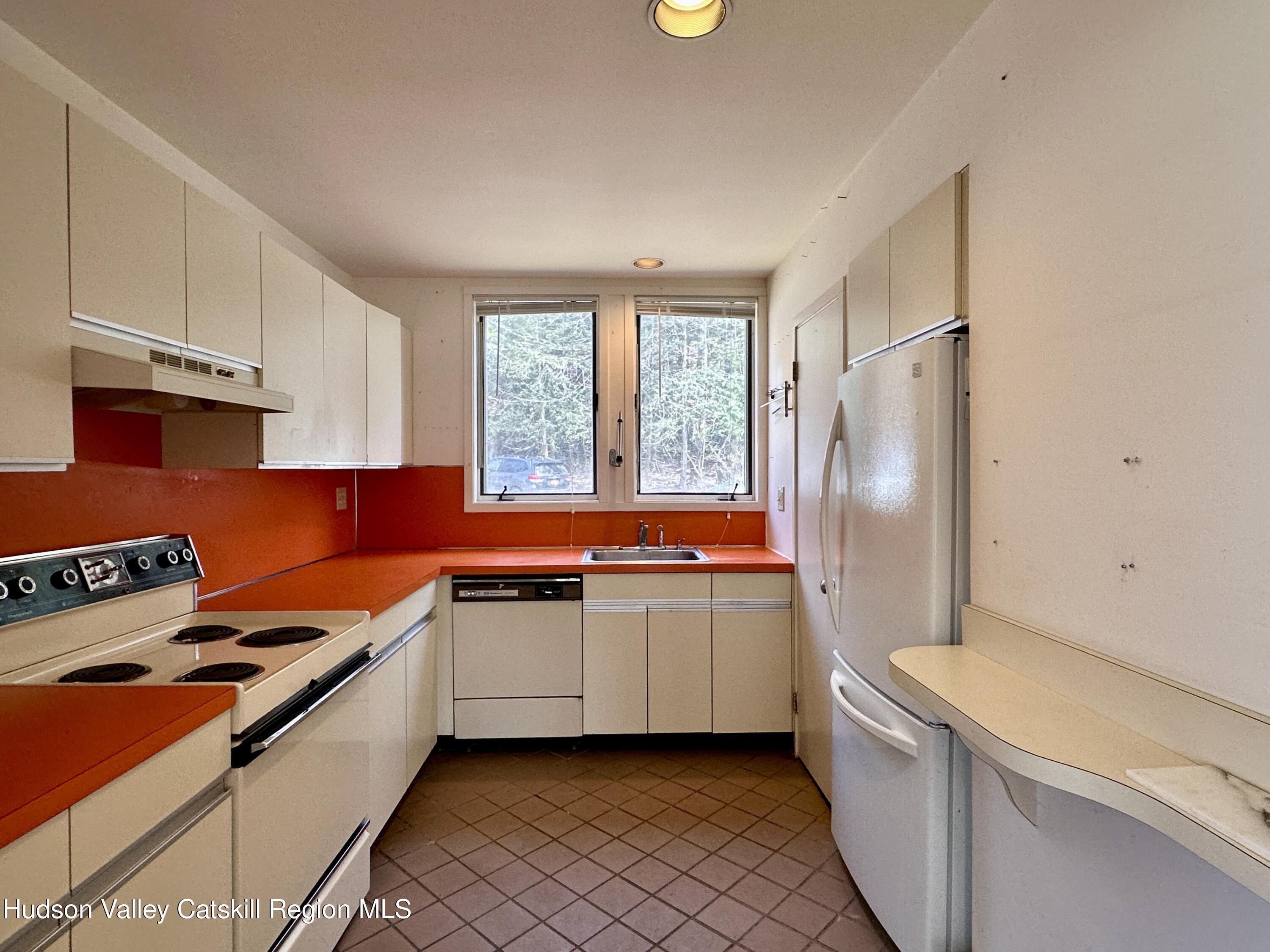 260 Pines Drive, Unit 82 Roxbury, NY 12421 - Photo 14 of 31 a kitchen with stainless steel appliances a sink a stove and a refrigerator