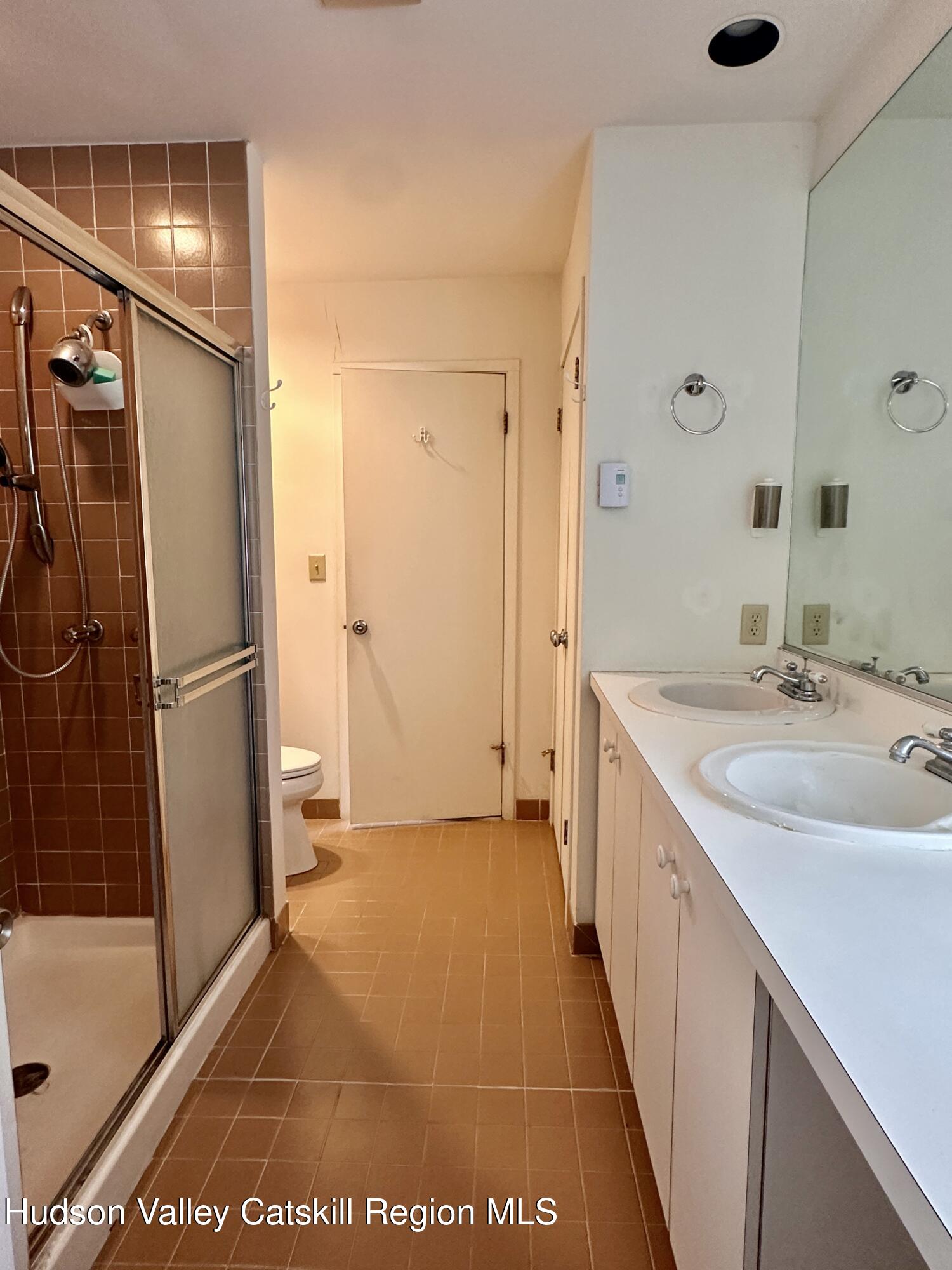 260 Pines Drive, Unit 82 Roxbury, NY 12421 - Photo 26 of 31 a bathroom with a double vanity sink a mirror and a shower
