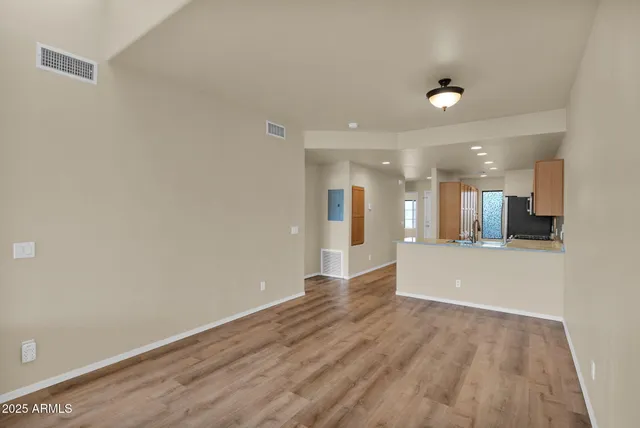 a view of a big room with wooden floor and a large window