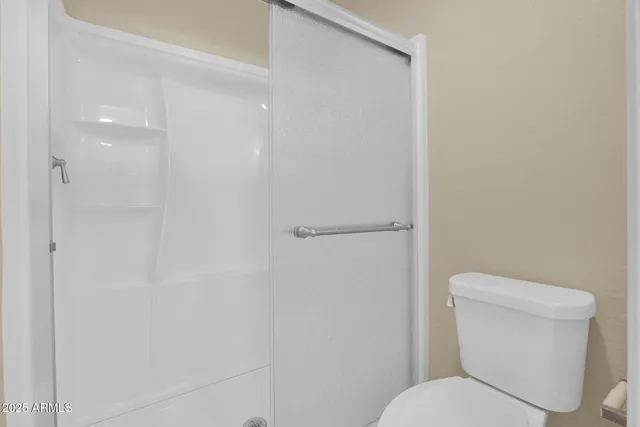 a white toilet sitting next to a shower
