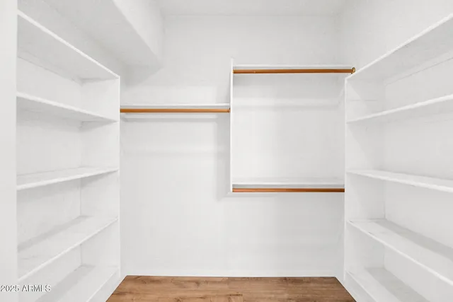 a view of walk in closet with empty racks