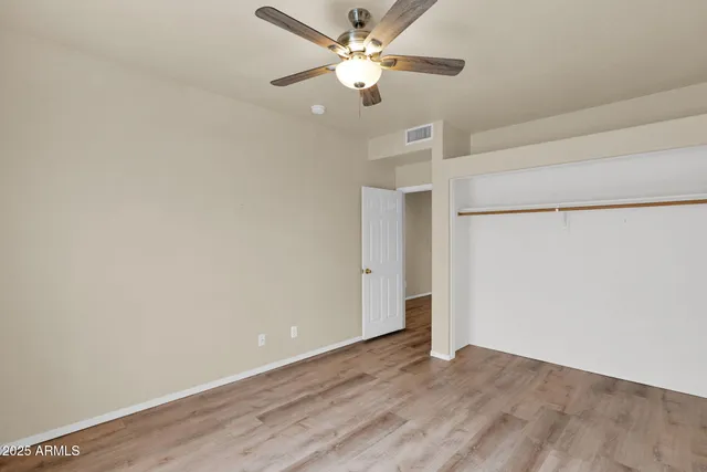 an empty room with a ceiling fan and a window
