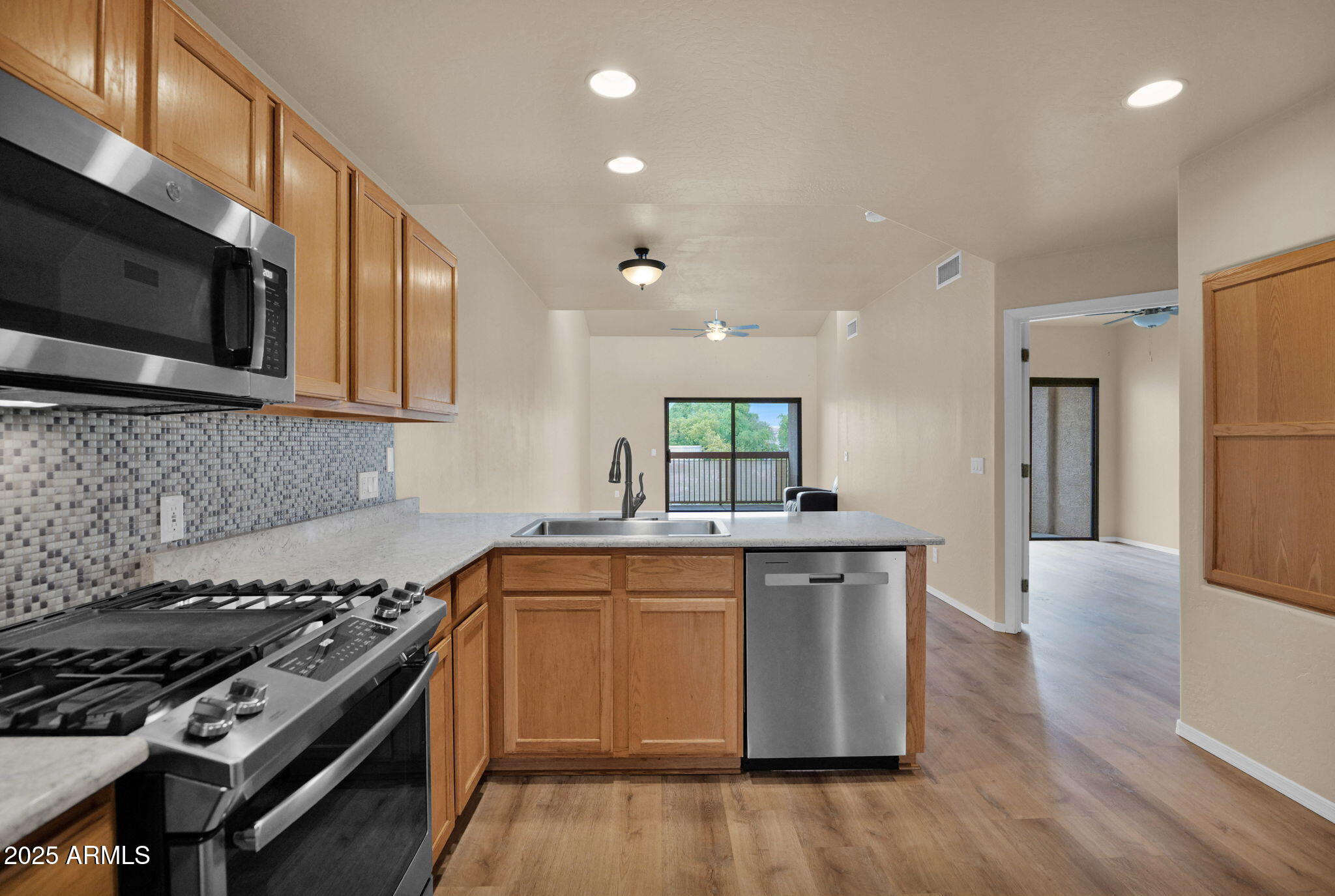 205 North 74th Street, Unit 260 Mesa, AZ 85207 - Photo 3 of 37 a kitchen with stainless steel appliances a sink stove and wooden floor
