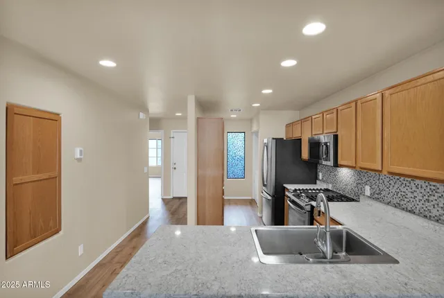 a kitchen with stainless steel appliances granite countertop a refrigerator and a sink