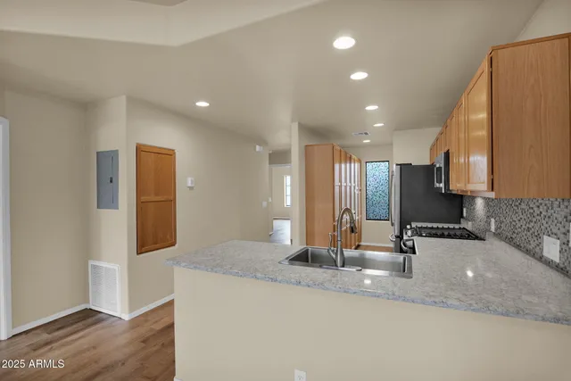 a kitchen with kitchen island granite countertop a sink and a refrigerator