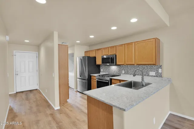 a kitchen with stainless steel appliances granite countertop a sink a stove and a refrigerator