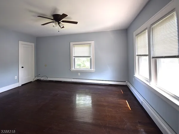 a view of a room with wooden floor and window