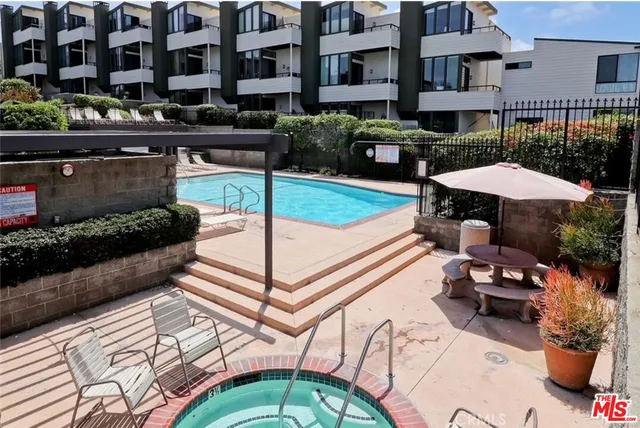 a view of a patio with table and chairs under an umbrella