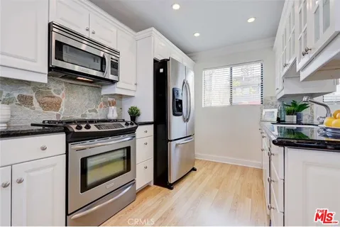 a kitchen with stainless steel appliances a stove microwave and sink