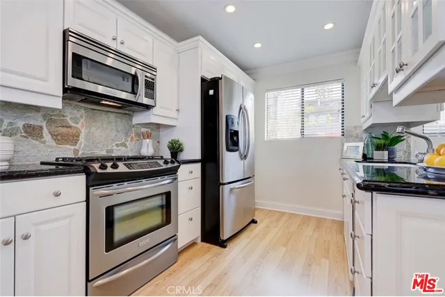 a kitchen with stainless steel appliances a stove microwave and sink