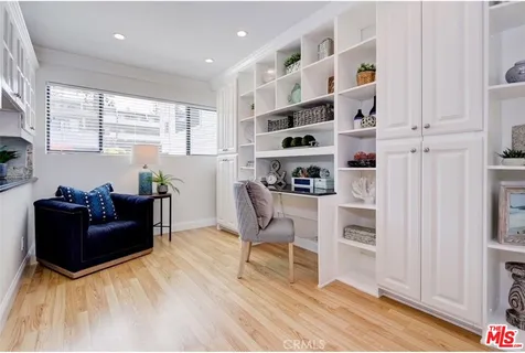 a living room with furniture cabinets and a window