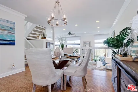 a dining room with furniture a chandelier and wooden floor