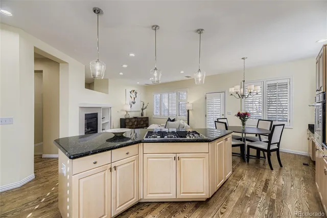 a kitchen with stainless steel appliances granite countertop a stove a sink a dining table and chairs