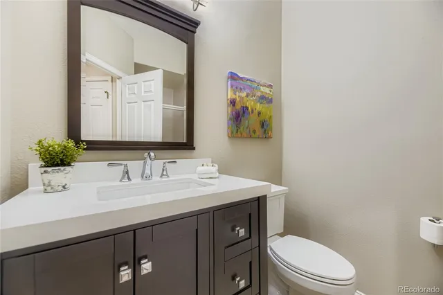 a bathroom with a sink a toilet and mirror