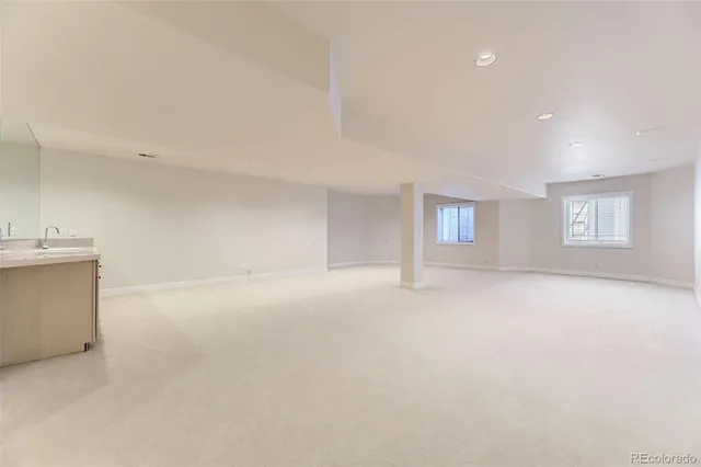a large white kitchen with a sink and dishwasher with a large window