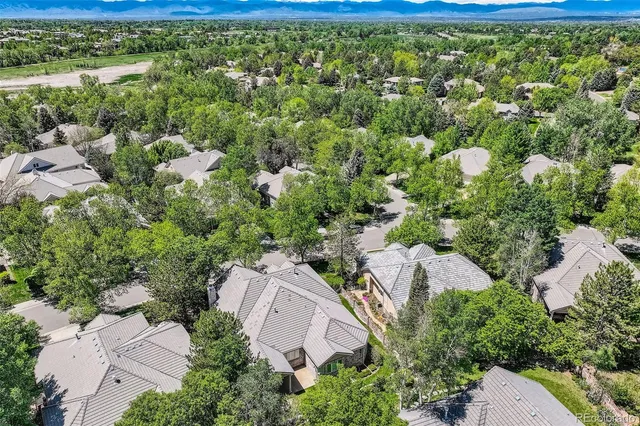 an aerial view of residential house with outdoor space and trees all around