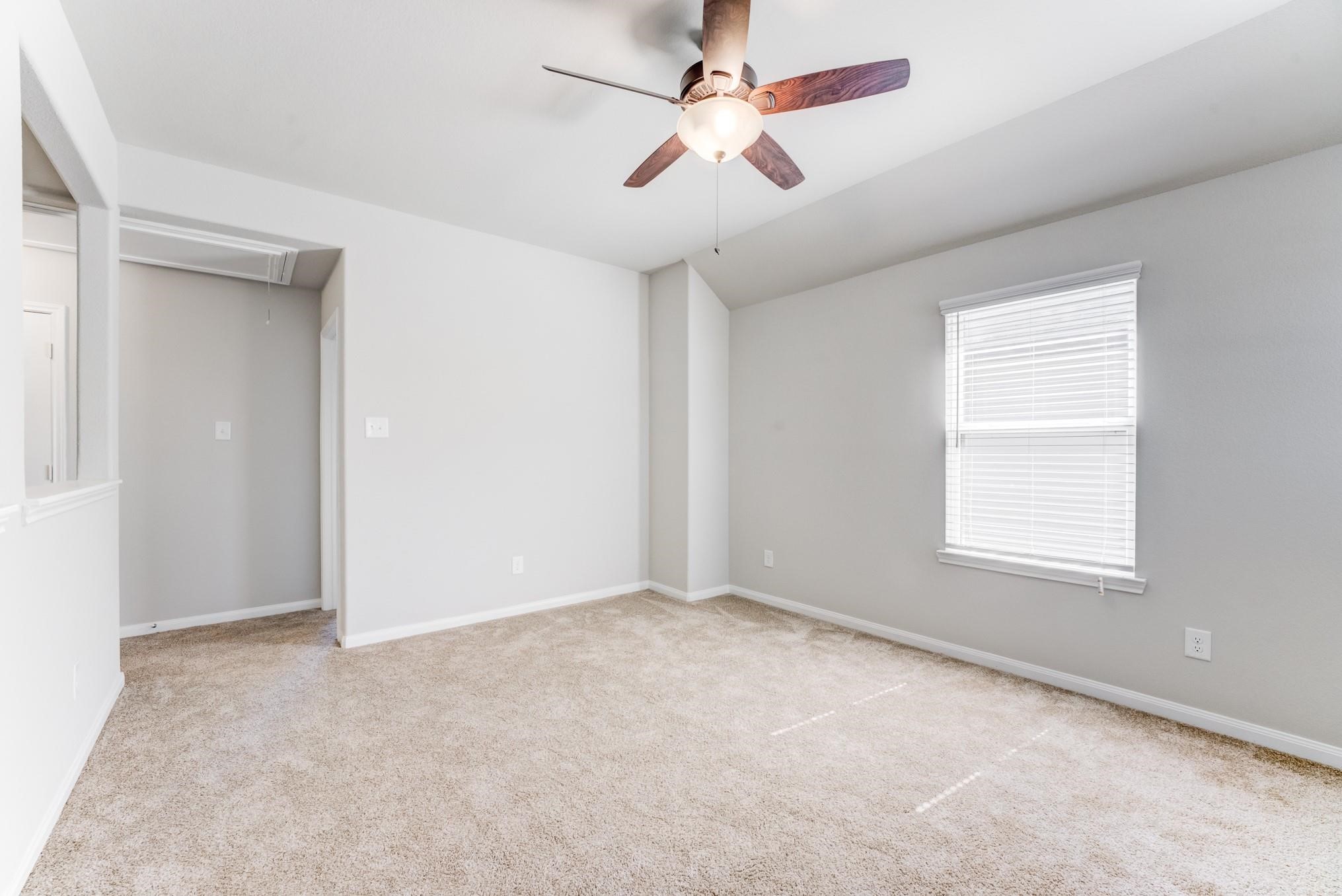 5842 Adelaide River Drive Katy, TX 77449 - Photo 24 of 40 an empty room with a window and a fan