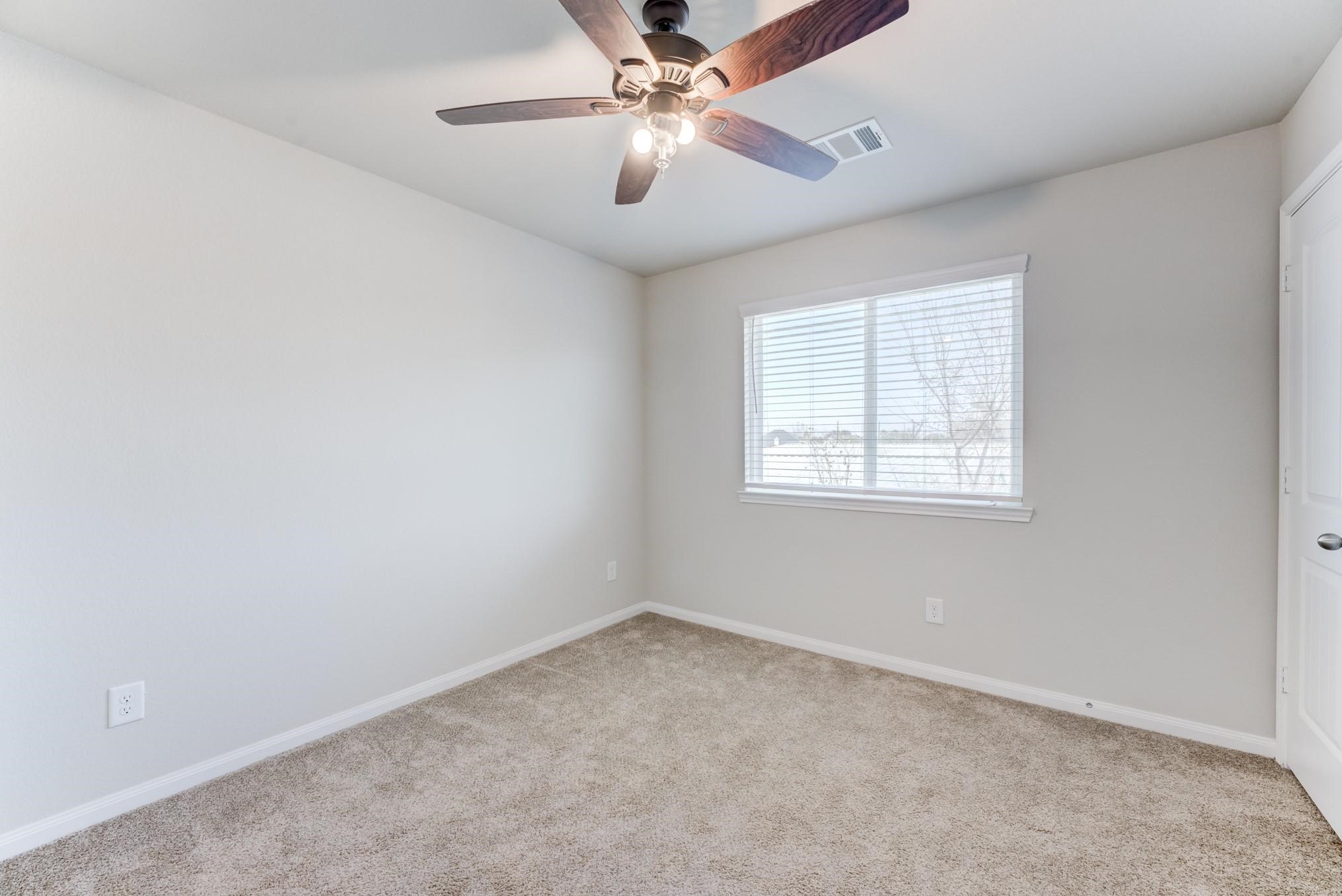 5842 Adelaide River Drive Katy, TX 77449 - Photo 28 of 40 an empty room with a window and a ceiling fan