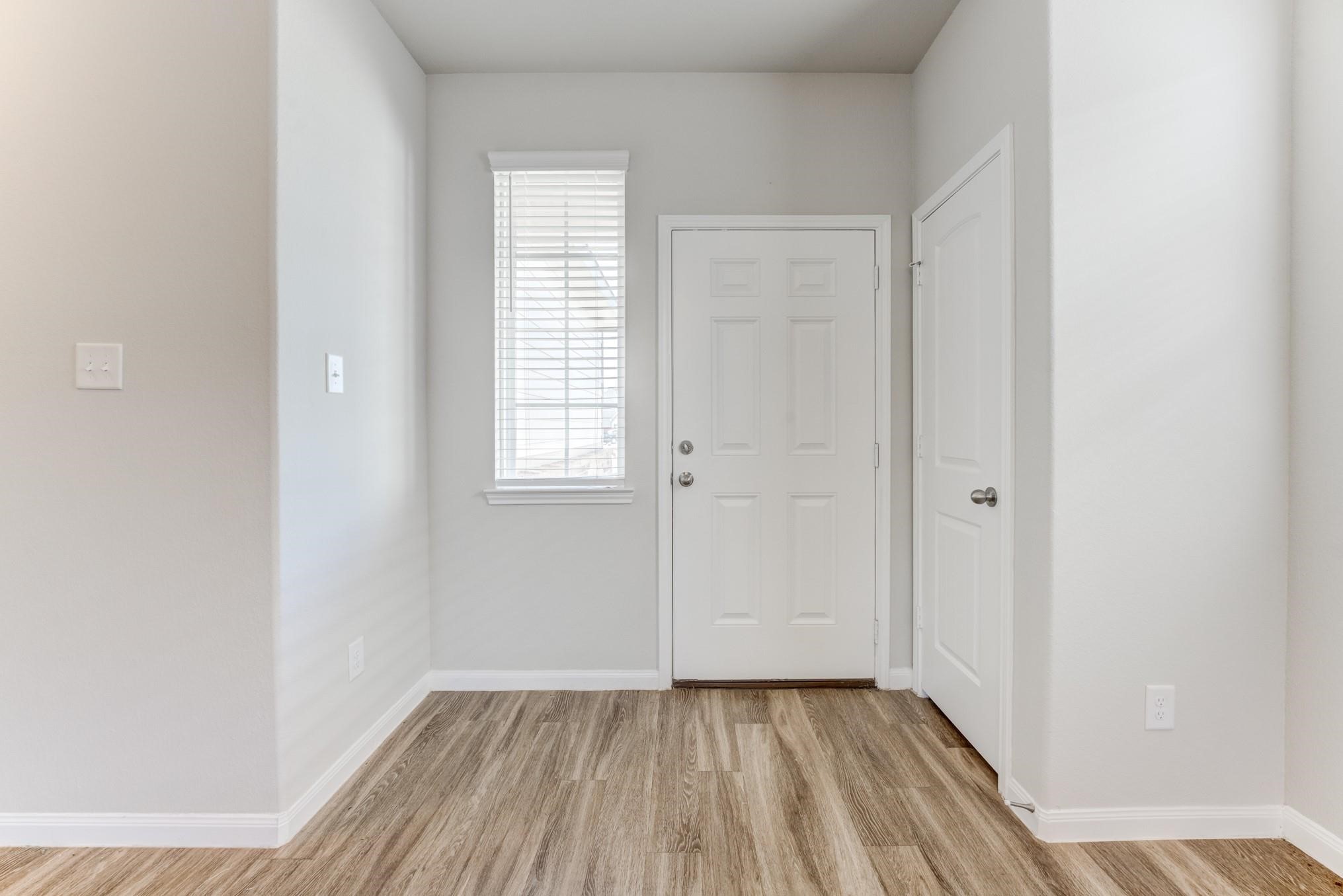 5842 Adelaide River Drive Katy, TX 77449 - Photo 5 of 40 an empty room with wooden floor and windows