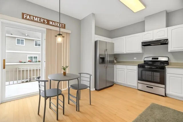 a kitchen with stainless steel appliances a stove a sink cabinets and a dining table