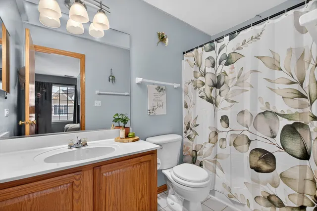 a bathroom with a granite countertop toilet sink and mirror