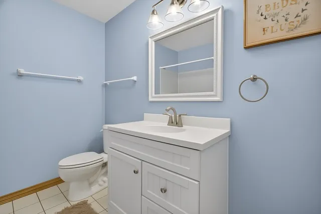 a bathroom with a toilet sink vanity and mirror