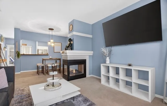 a living room with furniture a fireplace and a flat screen tv