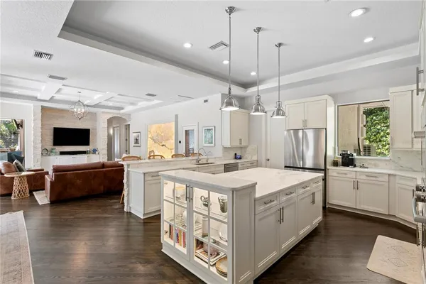 a kitchen with stainless steel appliances kitchen island granite countertop a stove a sink and a refrigerator
